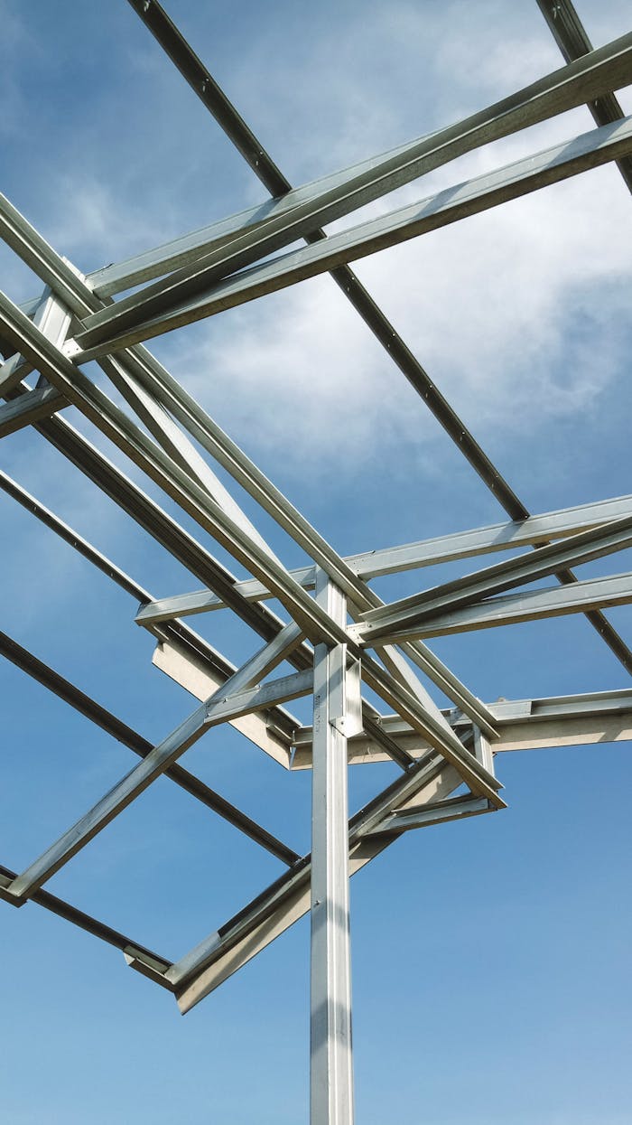 A structural steel framework set against a clear blue sky.